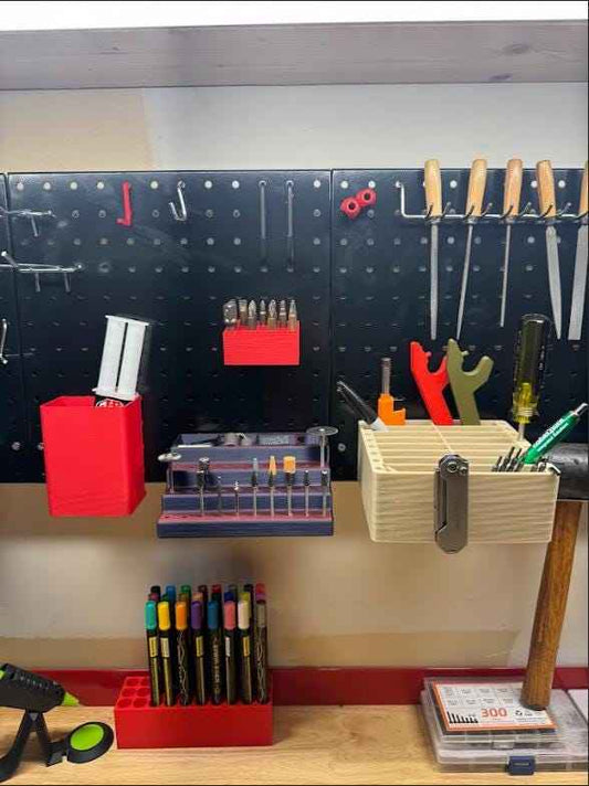 Pegboard attachment set in red on a black pegboard above a bench