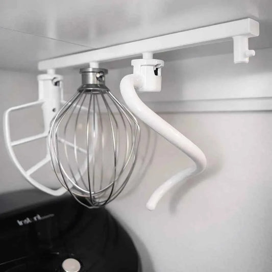 Slide-out KitchenAid mixer attachment holder holding whisk, paddle and dough hook
